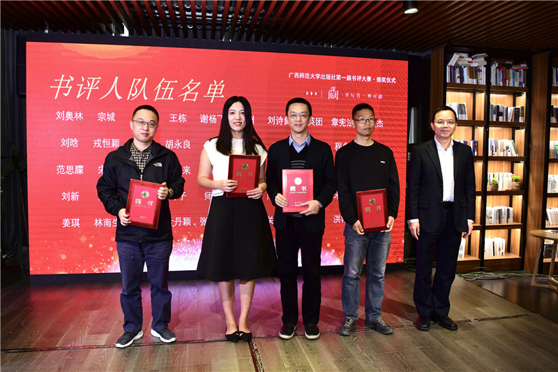 廣西師范大學(xué)出版社集團(tuán)黨委副書記、總編輯湯文輝（右一）為書評(píng)人代表頒發(fā)聘書（李顯楊攝）.jpg