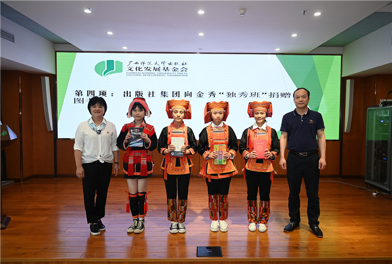 廣西師范大學出版社集團副總裁、工會主席莫曲波（右一）代表出版社向金秀“獨秀班”同學贈送圖書（李顯楊攝）.jpg