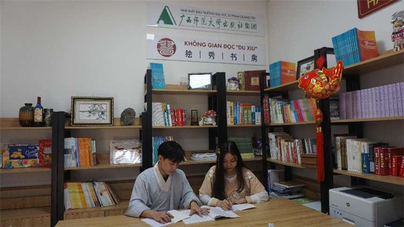 身著漢服的學(xué)生在獨(dú)秀書房·越南河內(nèi)大學(xué)孔院店內(nèi)閱讀.jpg