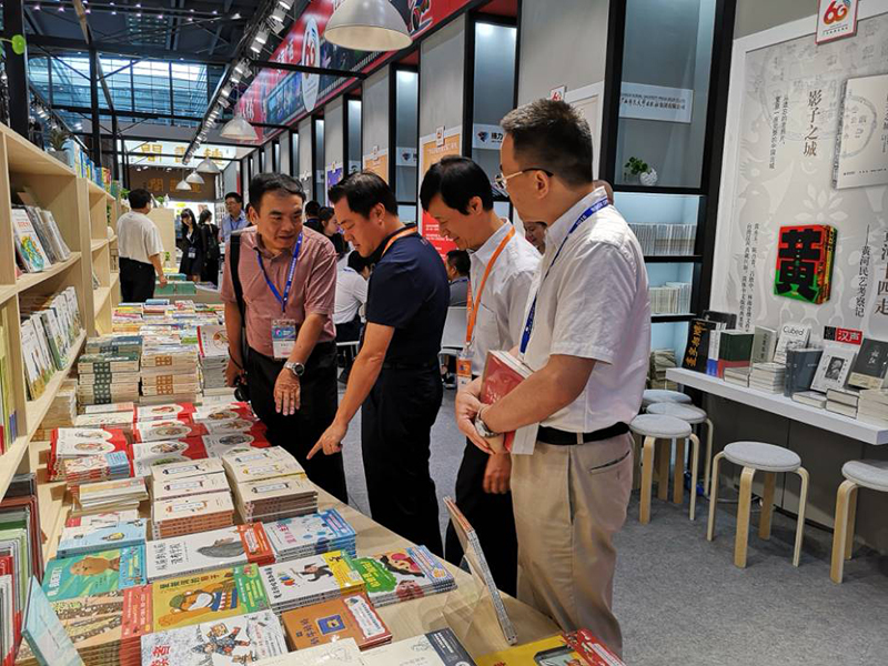 自治區(qū)政協(xié)科教文衛(wèi)體委員會主任委員彭綱（左二），自治區(qū)新聞出版廣電局黨組成員、副局長朱為范（右二）到集團公司展位視察.jpg